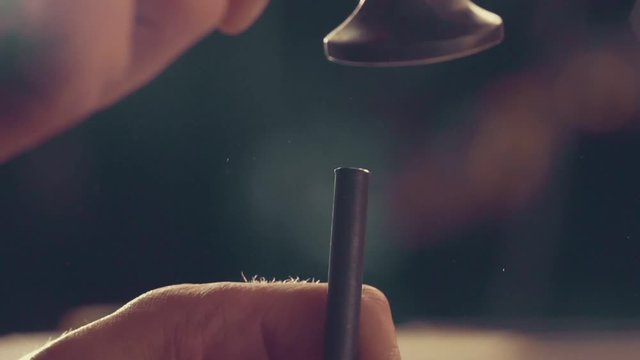 The master makes shoes in the workshop. Close up of hammer and piercer to make holes in leather