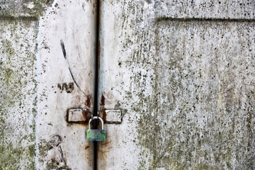Padlock, portable lock, on rusty metal gate