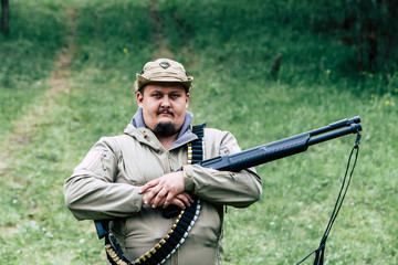 Hunter with a gun. Standing in the forest and waiting for prey