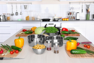 Fresh vegetables and utensils for cooking classes on wooden table