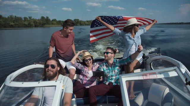 Group of diverse cheerful friends on boat celebrating Independence day and having fun.
