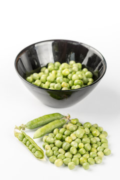 Fresh raw green peas in the bowl isolated over white background