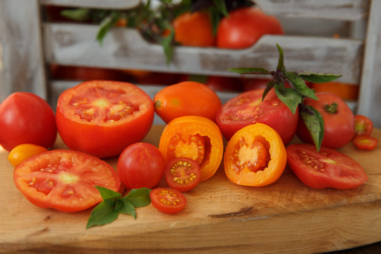 Tomatoes and basil on a wooden board in a rustic style 