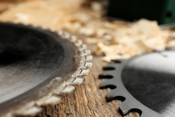 Circular-saw disks on wooden table in carpenter's workshop, closeup