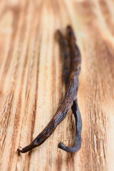 Dried vanilla sticks on wooden background, closeup