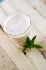 Obraz na płótnie Canvas Milk shake yogurt with strawberry slices on a wooden background.