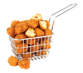 Fried breadcrumb covered chicken popcorn in a small wire frying basket isolated on a white background