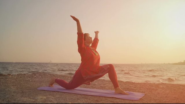 yoga at sunset on the beach. woman doing yoga, performing asana