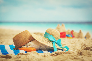 Fototapeta na wymiar hats, bag, suncream and glasses on beach
