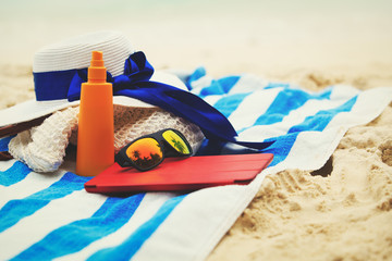 bag, suncream, glasses and touch pad on beach