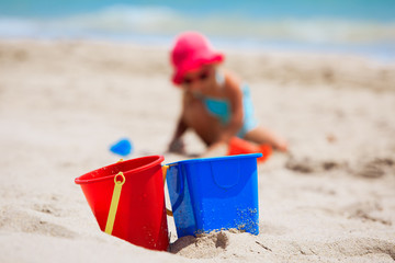 kids toys and little girl play with sand on beach