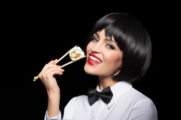 Naklejka premium Woman in texedo holding suschi by chopsticks isolated