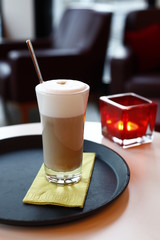 A glass latte macchiato in the cafe, the background with sharpening depth