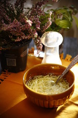 Noodle soup in a small bowl, stands on a wooden table