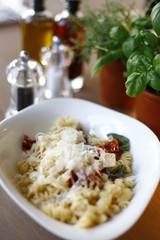 Pasta dish in an oval plate, in the restaurant on a wooden table