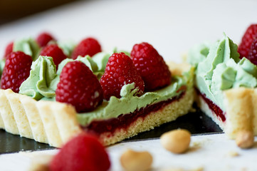 Pistachio tart. Pistachio tart on white Belgian chocolate BARRY with a layer of raspberry confit, crispy shortbread base, fading cream and juicy raspberries.A classic combination in miniature format.