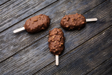 Ice cream in chocolate glaze in wooden background