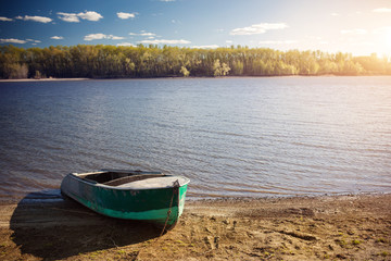 An old boat on the shore of the pond