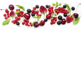 Top view. Various fresh summer berries on white background. Ripe cherries, currants, strawberries, mint and basil leaves. Berries at border of image with copy space for text. Background berries.
