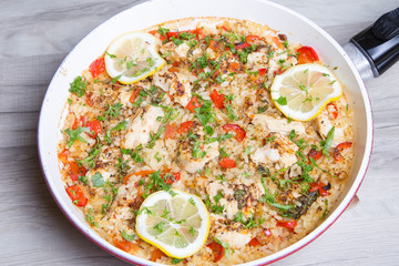 Paella with chicken, tomatoes and pepper . Traditional Spanish dish. Selective focus