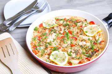 Paella with chicken, tomatoes and pepper . Traditional Spanish dish. Selective focus