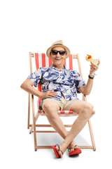 Elderly tourist with a cocktail sitting in a sun lounger