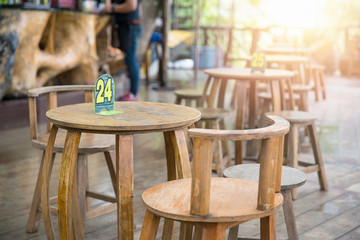 Wooden tables and chairs with number inside restaurant