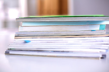 A stack of documentation is on the desktop in the office