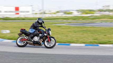 A motorcycle racer makes a practice run on a sports track. Motion blur.
