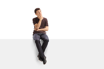 Pensive teenager sitting on a panel