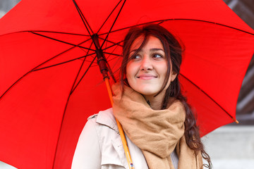 Portrait of smiling young woman with red umbrella.