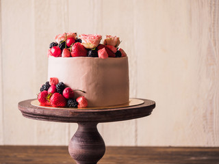 Pink cake with berries and flowers