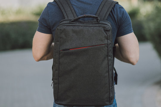 Young man with big and grey laptop case