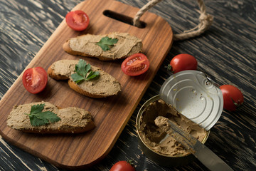 Liver pate on the bread on wooden tray.