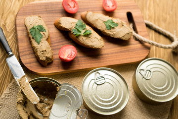 Liver pate on the bread on wooden tray.