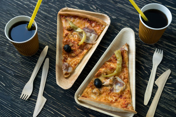 A slices of pizza is on a wooden plate.