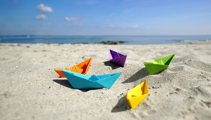 bunte Papierboote im Sand