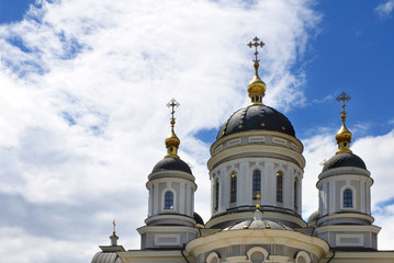 Fototapeta na wymiar orthodox crosses on gold domes (cupolas) blue sky with clouds.
