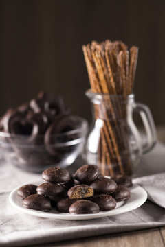 Chocolate biscuits with filling and wheat sticks with a sesame on a table with a towel.