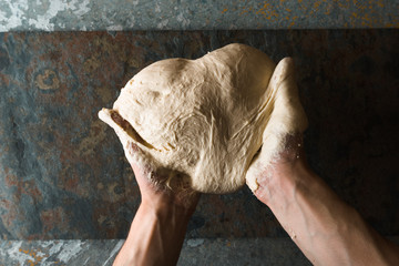 Hands with heart shaped dough top view