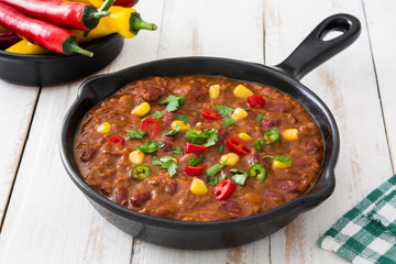 Traditional mexican tex mex chili con carne in a frying pan on white wooden table
