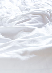 Fototapeta na wymiar White blanket crumpled on the bed