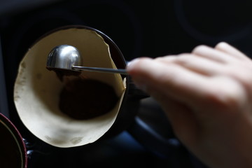 Close up of male hands that prepare a delicious coffee with naturally colors in soft-focus in the background.