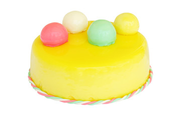 yellow birthday cake with colored balls isolated on white
