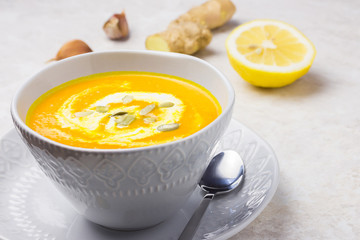 Carrot, ginger,  turmeric soup in a bowl on marble background. 