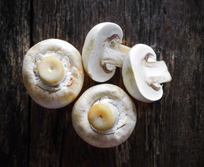 Fresh white mushrooms champignon on wooden background