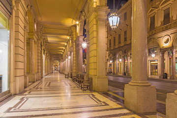 Fototapeta na wymiar Turin - The porticoes of of Via roma street at dusk.