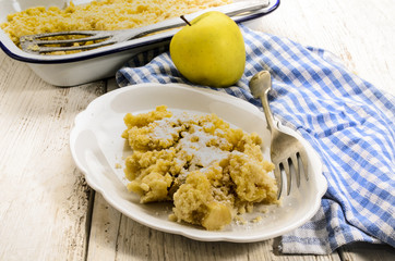 british apple crumble, freshly baked, served with powdered sugar on a plate