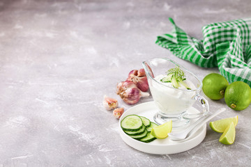 Tzatziki sauce in a glass sauce-boat. Ingredients for a dzadziki. Turkish dish cacik. Selective focus. Copy space