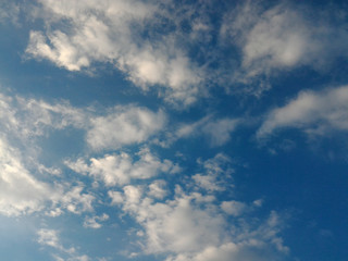 Sun hidden behind clouds with rays of light.  Blue sky with clouds with place for your text.